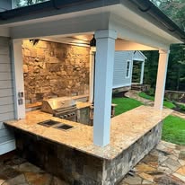Covered outdoor bar with a stone counter and stacked stone base