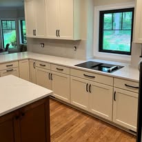 Kitchen with light cabinetry and pale stone countertops and backsplash